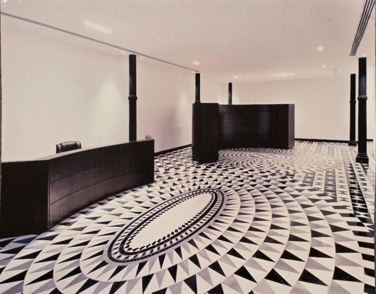 Office lobby with a black, white and gray marble floor laid in sweeping oval patterns