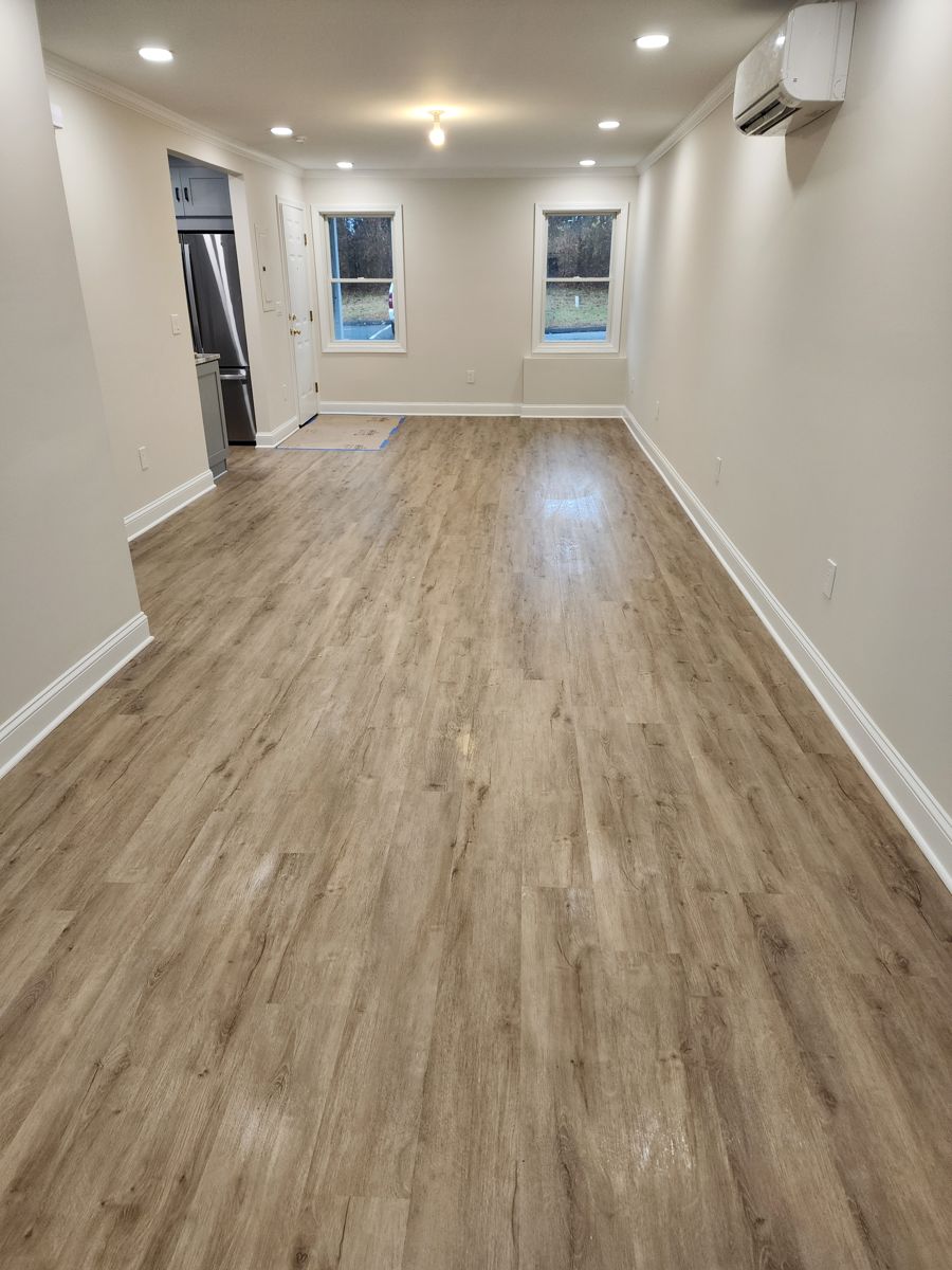 Long living area with new wood-look luxury vinyl plank flooring, fresh paint and new windows